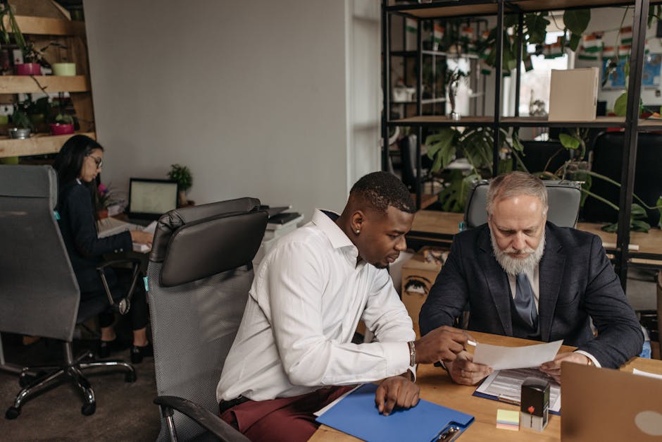 Professional team in office setting reviewing documents and working on business strategy.